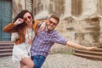 funny young couple in love traveling, vintage style, europe vacation, honey moon, sunglasses, old city center, happy positive mood, smiling, embracing