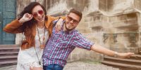 funny young couple in love traveling, vintage style, europe vacation, honey moon, sunglasses, old city center, happy positive mood, smiling, embracing